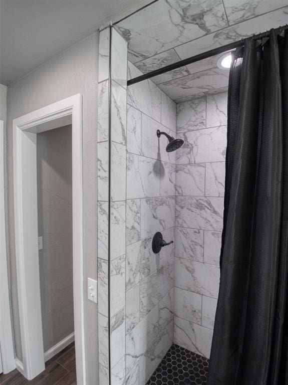 bathroom with curtained shower and hardwood / wood-style floors