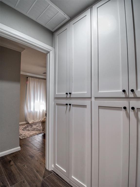 interior space with crown molding and dark wood-type flooring