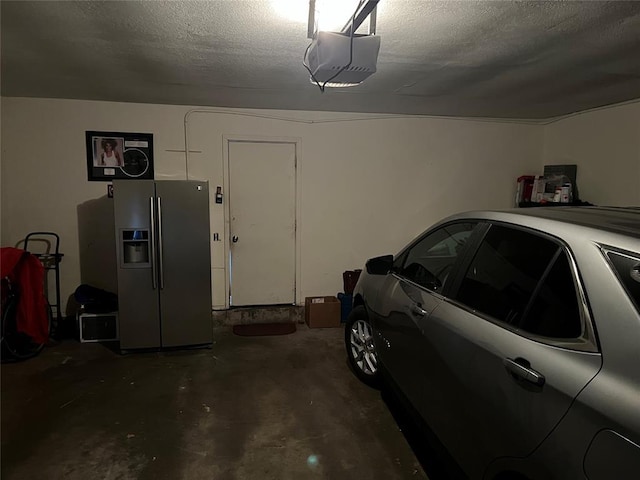 garage with a garage door opener and stainless steel fridge with ice dispenser