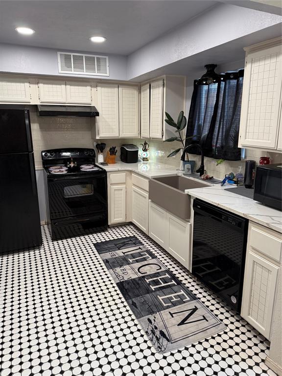 kitchen with recessed lighting, visible vents, under cabinet range hood, and black appliances