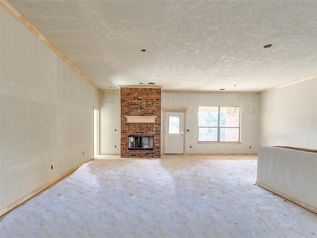 unfurnished living room with a textured ceiling, a brick fireplace, and ornamental molding