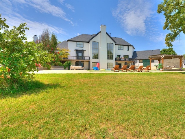 back of property with a patio, a pergola, and a lawn