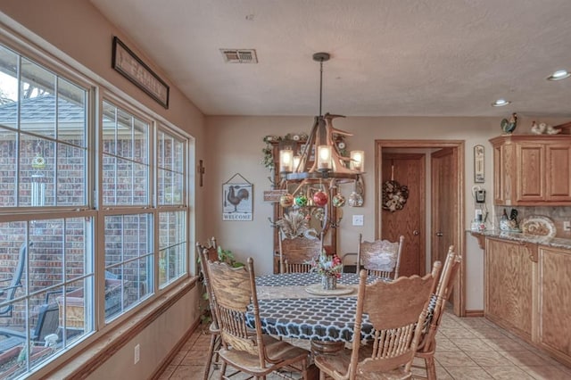 tiled dining space with a notable chandelier and plenty of natural light