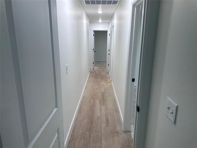 corridor with light hardwood / wood-style floors