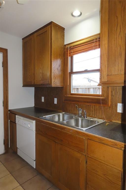 kitchen with light tile patterned flooring, white dishwasher, tasteful backsplash, and sink