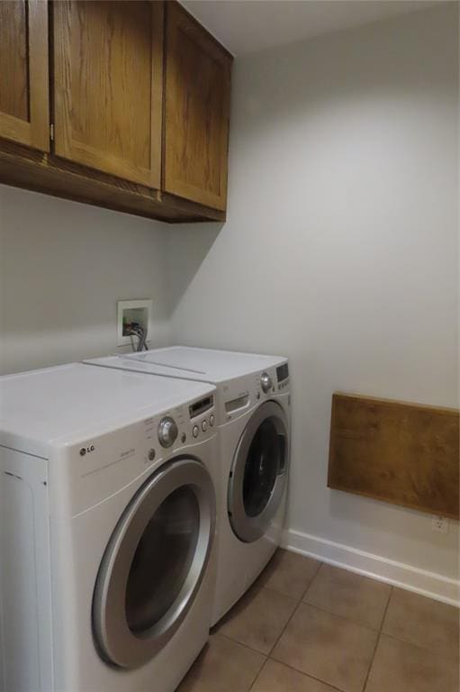 laundry room featuring tile patterned floors, cabinets, and separate washer and dryer