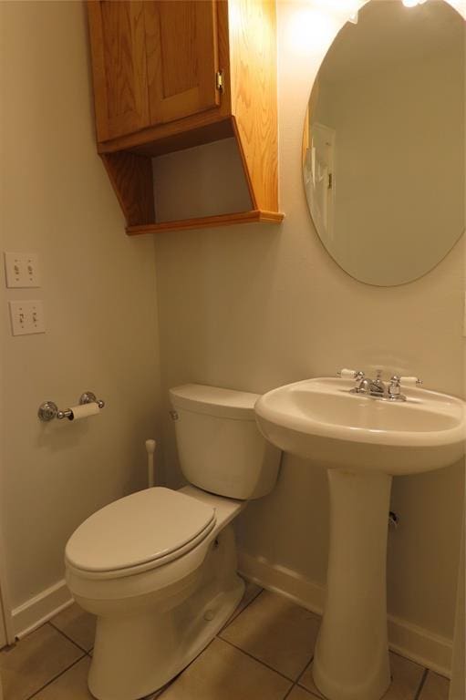 bathroom featuring tile patterned flooring, toilet, and sink