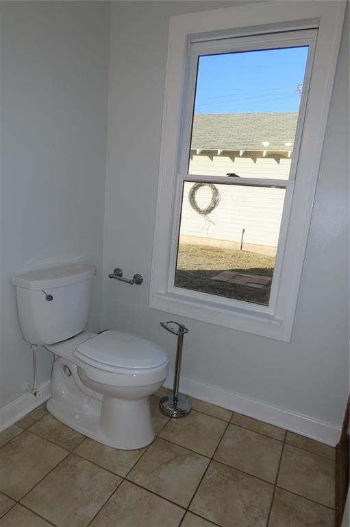 bathroom with toilet, plenty of natural light, and tile patterned flooring