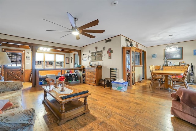 living room featuring hardwood / wood-style floors, ceiling fan, and crown molding