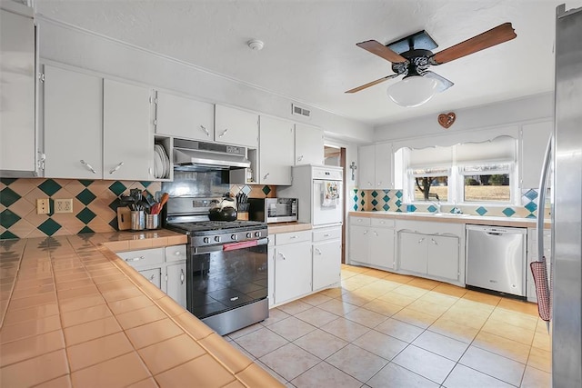 kitchen with stainless steel appliances, white cabinetry, and tasteful backsplash