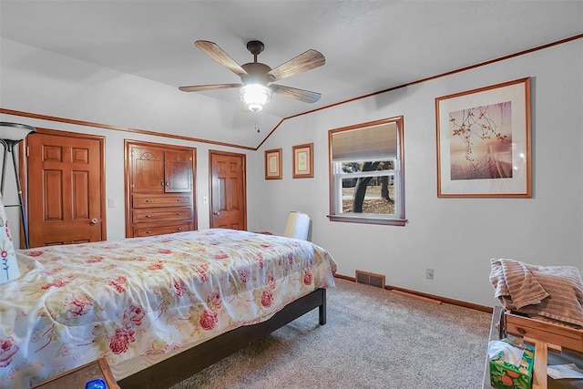 carpeted bedroom with ceiling fan, multiple closets, crown molding, and vaulted ceiling