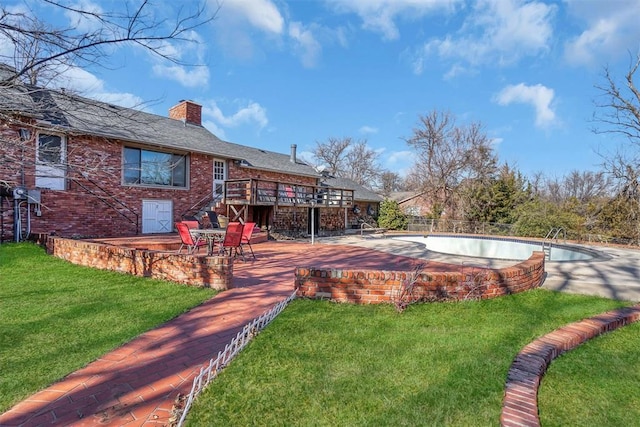 view of pool with a lawn, a patio area, and a wooden deck