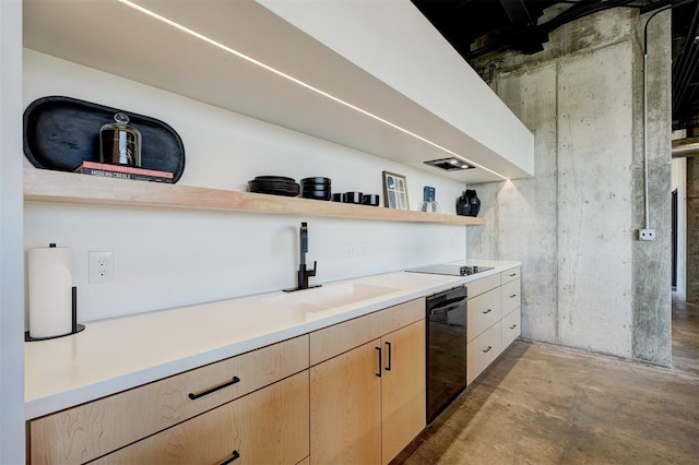 kitchen with concrete flooring, light brown cabinetry, sink, and black appliances