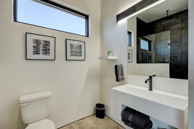 bathroom featuring toilet, a tile shower, and vanity