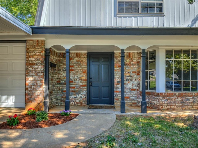 doorway to property featuring a porch and a garage