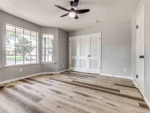 unfurnished bedroom with ceiling fan, a closet, and light hardwood / wood-style flooring