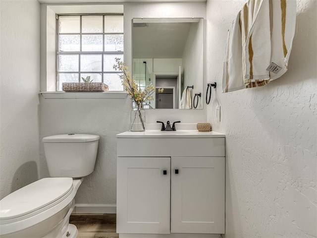 bathroom with hardwood / wood-style floors, vanity, and toilet