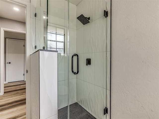 bathroom featuring wood-type flooring and walk in shower