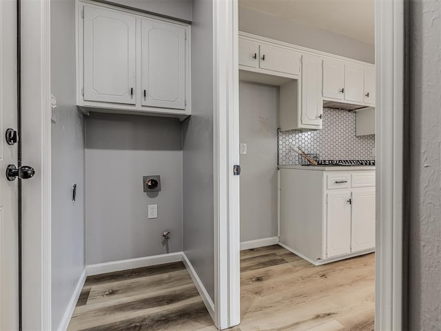 laundry room featuring electric dryer hookup, hookup for a gas dryer, and light hardwood / wood-style flooring