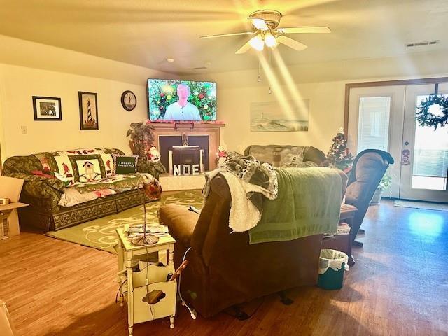 living room with ceiling fan, french doors, and wood-type flooring