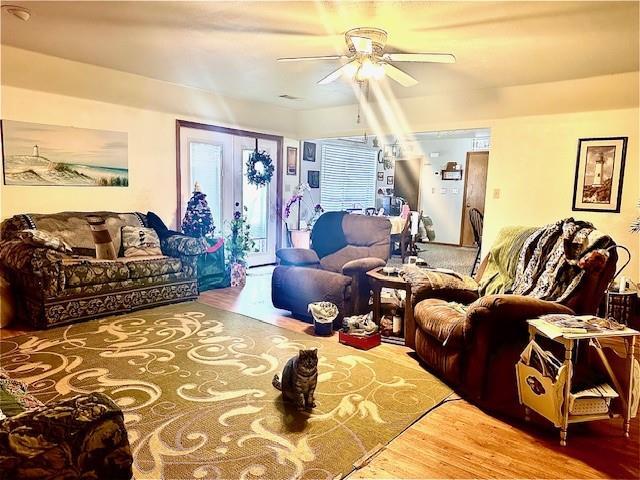 living room featuring ceiling fan, hardwood / wood-style floors, and french doors