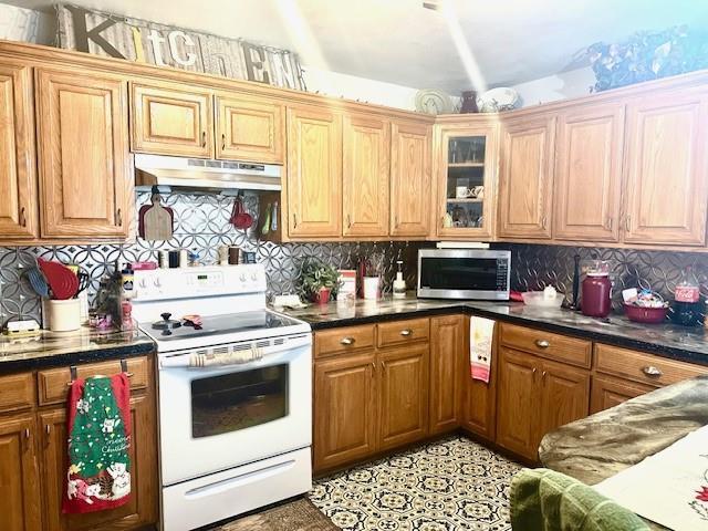 kitchen featuring white electric range and tasteful backsplash