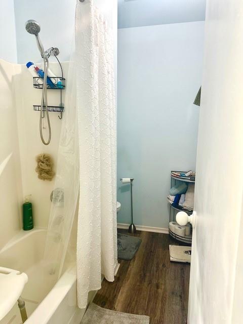 bathroom featuring hardwood / wood-style floors and shower / bath combination with curtain