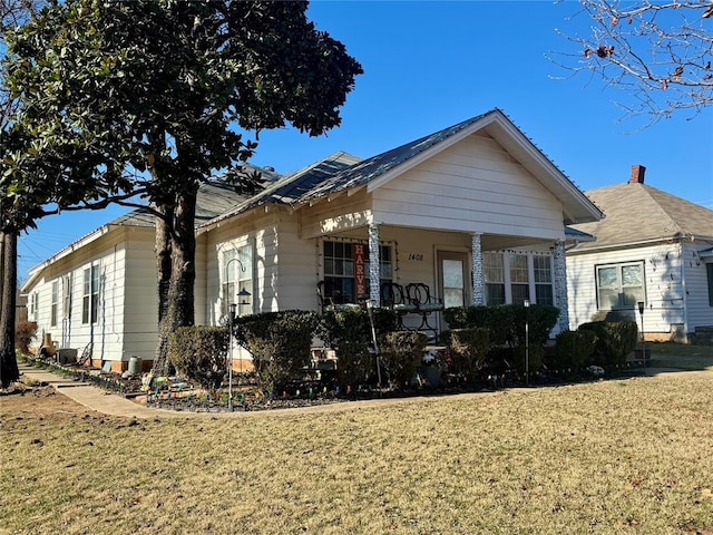 view of front of home featuring covered porch and a front yard