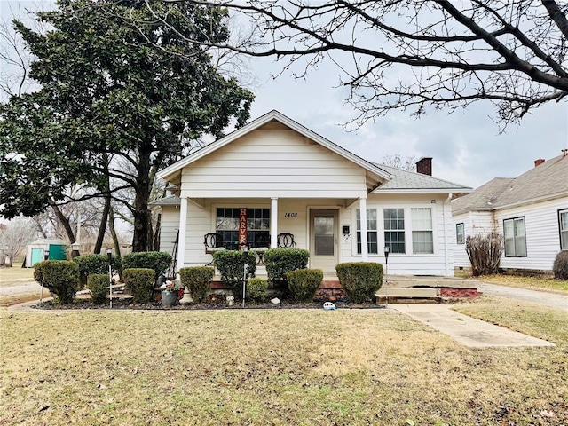 bungalow-style home with a porch and a front yard