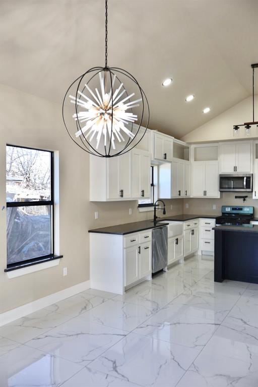 kitchen featuring stainless steel appliances, sink, pendant lighting, an inviting chandelier, and white cabinets