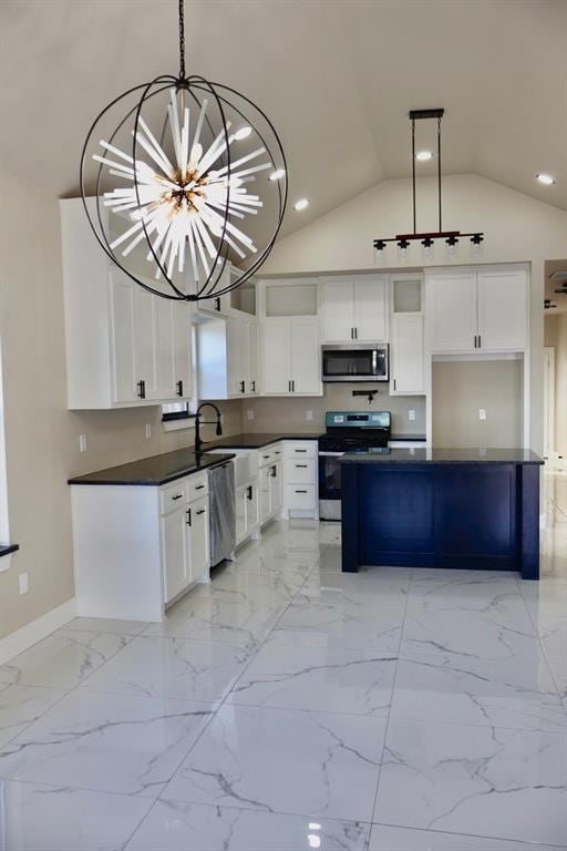 kitchen featuring pendant lighting, white cabinets, vaulted ceiling, appliances with stainless steel finishes, and a chandelier