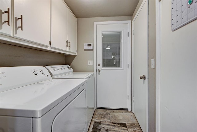 laundry room with cabinet space, stone finish floor, and independent washer and dryer