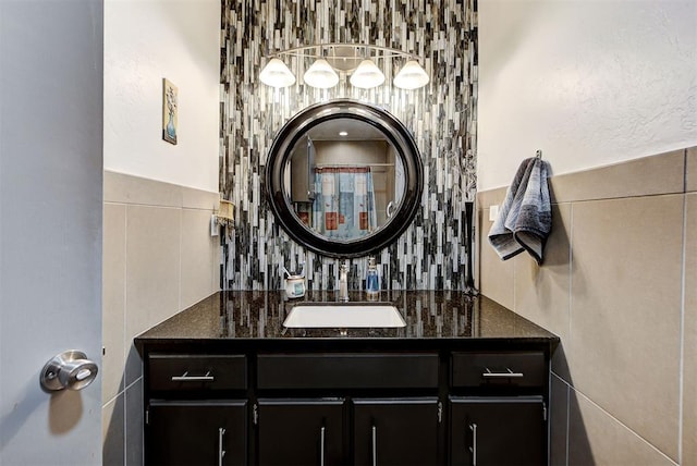 full bathroom with decorative backsplash, tile walls, and vanity