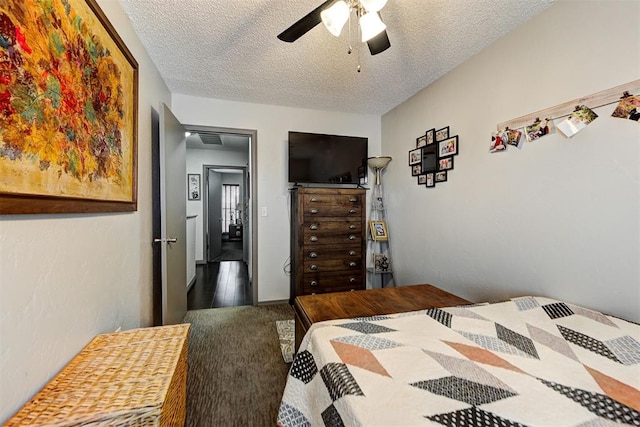 bedroom with carpet floors, visible vents, ceiling fan, and a textured ceiling