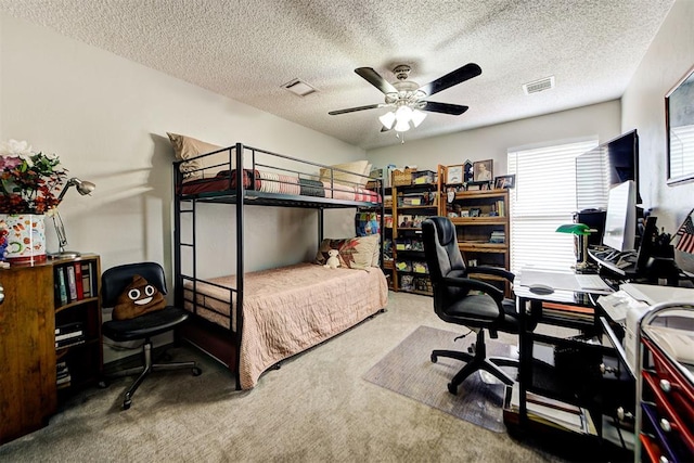 carpeted bedroom featuring ceiling fan, visible vents, and a textured ceiling