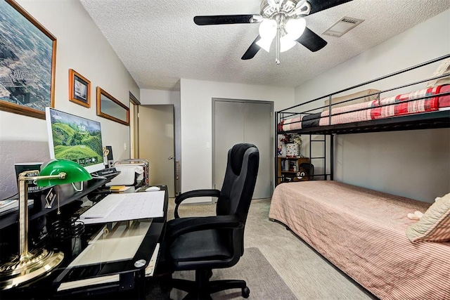 carpeted bedroom featuring ceiling fan, visible vents, and a textured ceiling