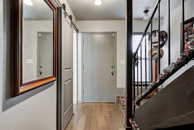 foyer with light wood finished floors and a barn door