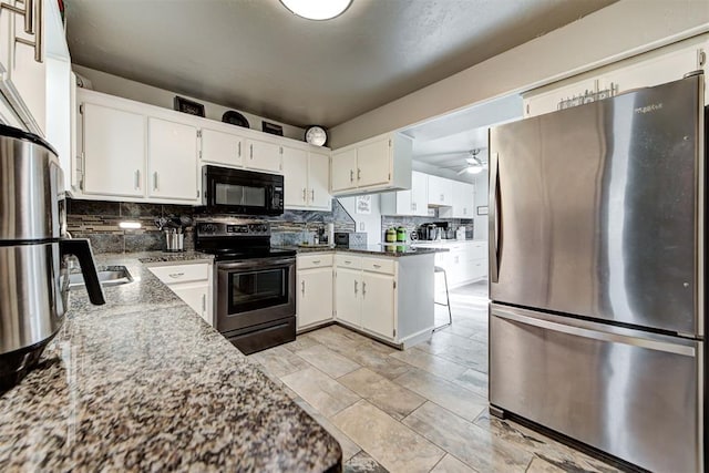 kitchen with stone counters, tasteful backsplash, appliances with stainless steel finishes, a ceiling fan, and white cabinets