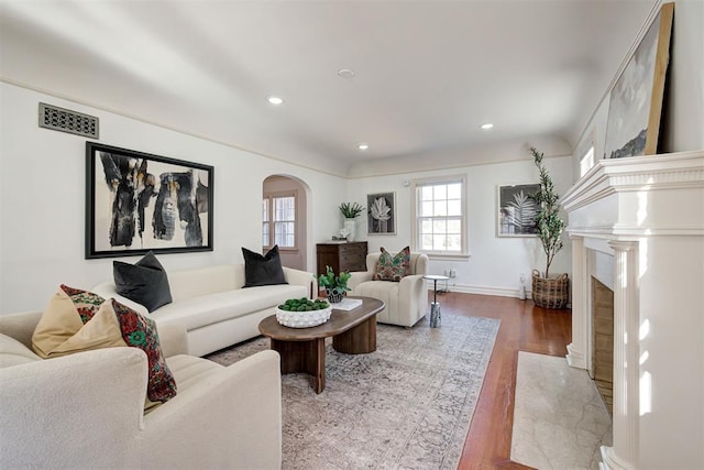 living room featuring a high end fireplace and wood-type flooring