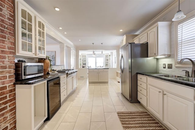 kitchen featuring a sink, wine cooler, glass insert cabinets, appliances with stainless steel finishes, and backsplash