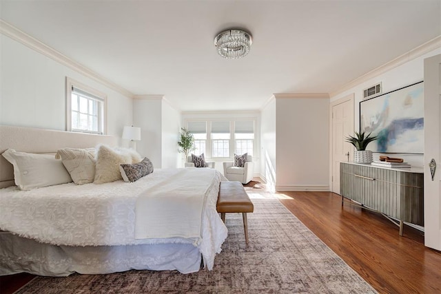 bedroom featuring multiple windows, wood finished floors, visible vents, and ornamental molding