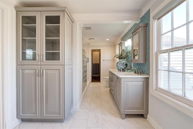 hall featuring baseboards, visible vents, recessed lighting, a sink, and marble finish floor