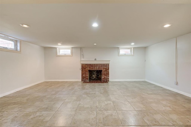 below grade area featuring a wealth of natural light, recessed lighting, and a brick fireplace