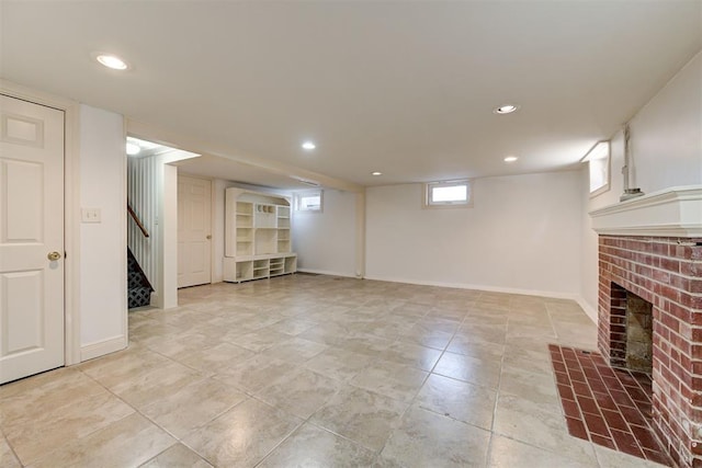 below grade area with stairs, a brick fireplace, and recessed lighting