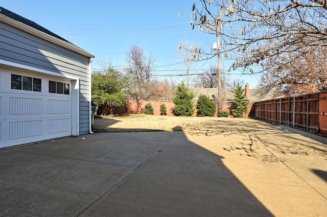 view of patio featuring a garage and fence