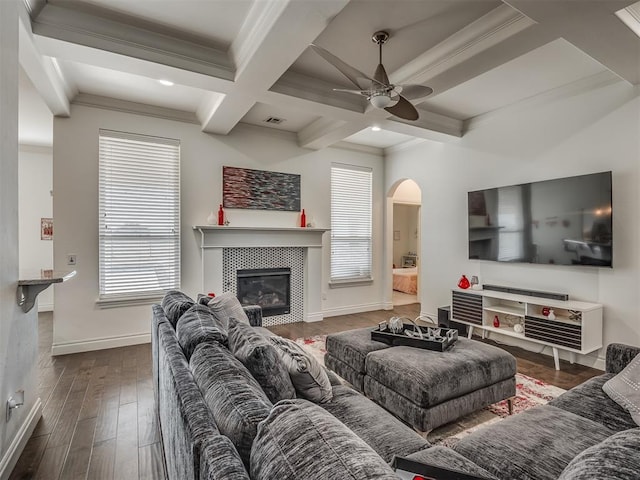 living room featuring ceiling fan, coffered ceiling, beamed ceiling, dark hardwood / wood-style floors, and a fireplace