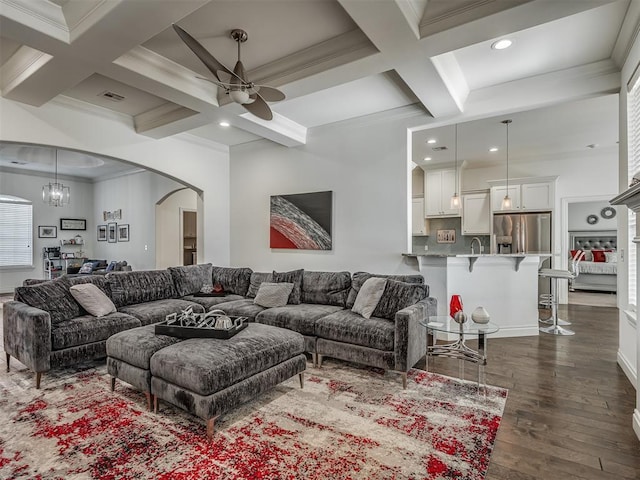 living room with sink, coffered ceiling, dark hardwood / wood-style flooring, beamed ceiling, and ceiling fan with notable chandelier