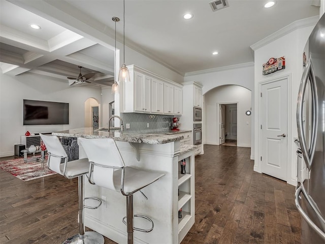 kitchen with coffered ceiling, white cabinets, hanging light fixtures, light stone countertops, and beamed ceiling