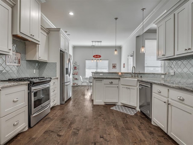 kitchen featuring light stone countertops, sink, hanging light fixtures, and appliances with stainless steel finishes