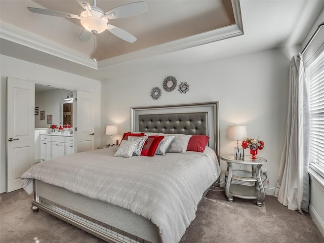 carpeted bedroom with ceiling fan, a raised ceiling, crown molding, and multiple windows